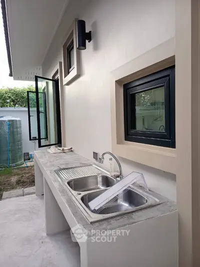 Modern outdoor kitchen with dual sink and open window design
