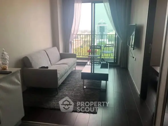 Modern living room with balcony view, sleek furniture, and natural light.