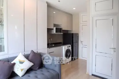 Modern compact living space with integrated kitchen appliances, sleek cabinetry, and a cozy sitting area, perfect for urban living.