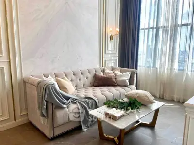 Luxurious living room with elegant tufted sofa and marble coffee table, perfect for sophisticated urban living.