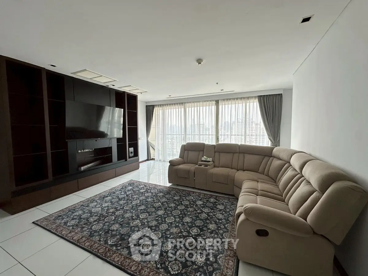 Spacious living room with large windows and modern furniture in a high-rise apartment.