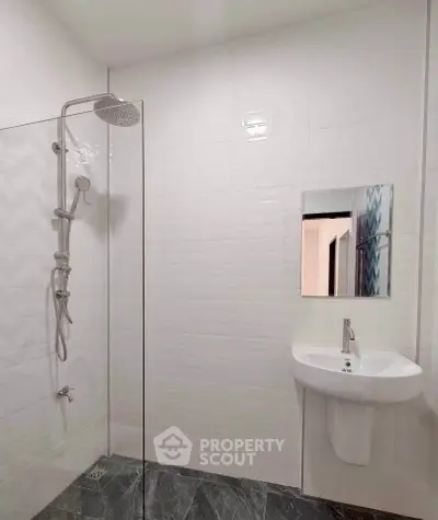 Modern minimalist bathroom with sleek shower and elegant sink design.