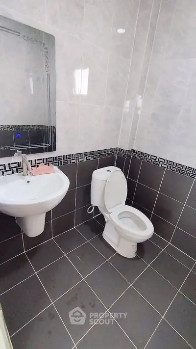 Modern bathroom with sleek tiles and contemporary fixtures in a stylish real estate property.