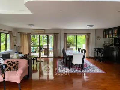 Spacious living room with elegant dining area and lush garden view, perfect for entertaining guests.