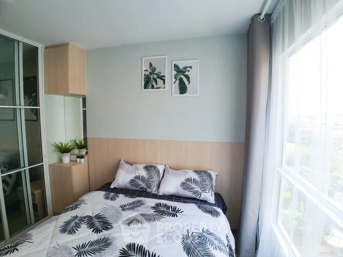 Cozy bedroom with large window and modern decor, perfect for relaxation.