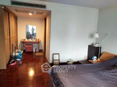 Spacious bedroom with wooden flooring and cozy decor