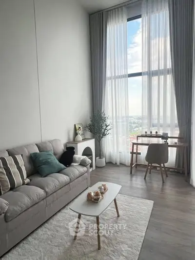 Modern living room with large window and stylish furniture, offering a bright and airy atmosphere.