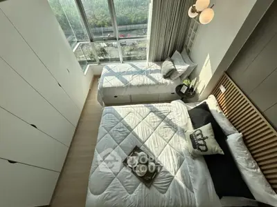 Modern bedroom with large windows and stylish decor, offering a cozy and inviting atmosphere.