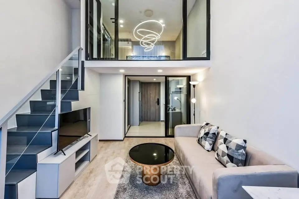 Modern duplex living room with stylish decor and glass staircase