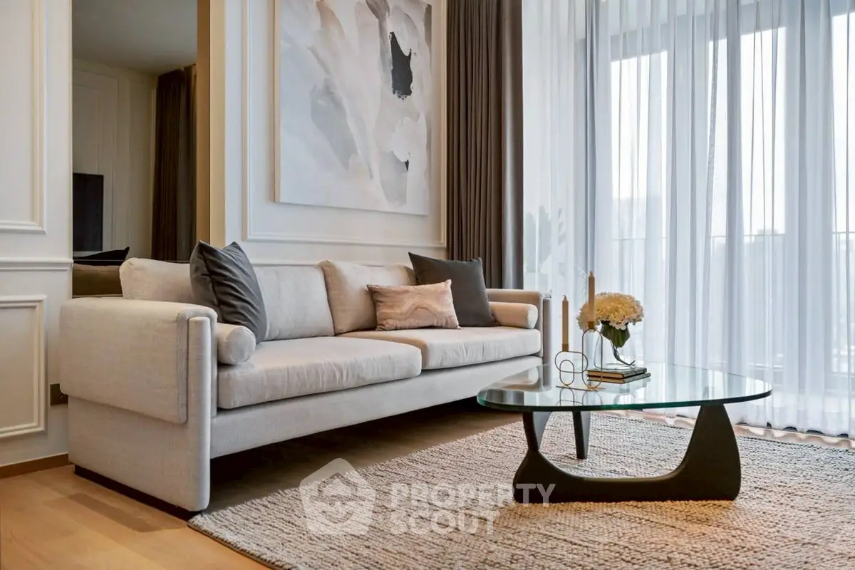 Elegant living room with modern sofa and glass coffee table, featuring floor-to-ceiling windows and stylish decor.