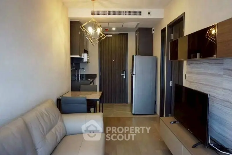 Modern living room with sleek furniture and open kitchen layout in a stylish apartment.