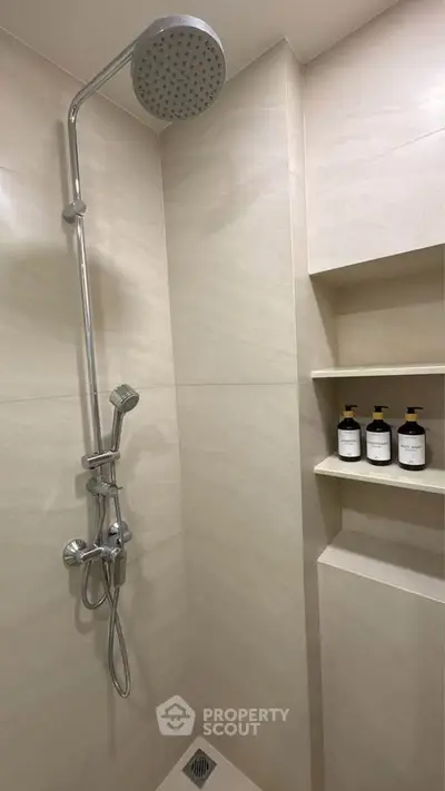 Modern bathroom shower with sleek fixtures and built-in shelving for toiletries.