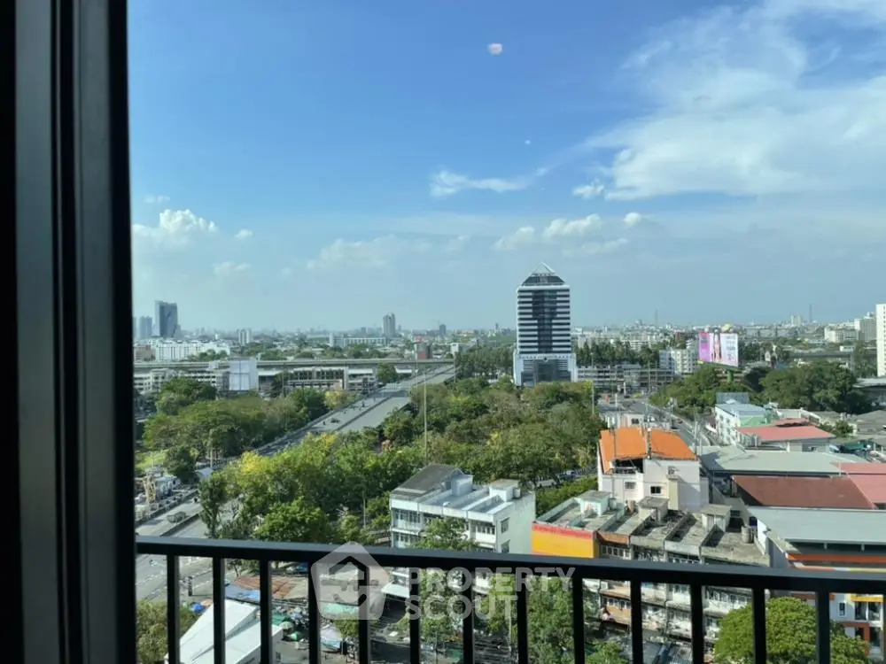 Stunning cityscape view from a high-rise balcony with clear blue skies.