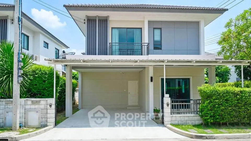 Modern two-story house with carport and lush greenery in a suburban neighborhood.