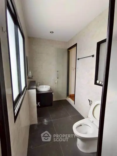 Modern bathroom with sleek design and large window for natural light.