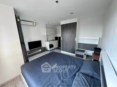 Modern studio apartment with sleek design, featuring a cozy bed, compact kitchen, and stylish storage solutions.