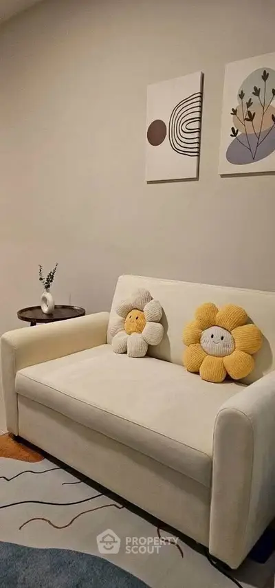 Cozy living room with modern decor and charming flower cushions on a white sofa.