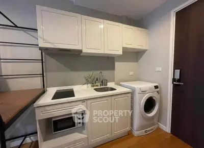Modern compact kitchen with washing machine and sleek cabinetry