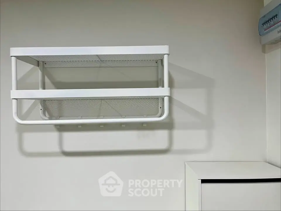 Minimalist white wall-mounted storage rack in modern interior space