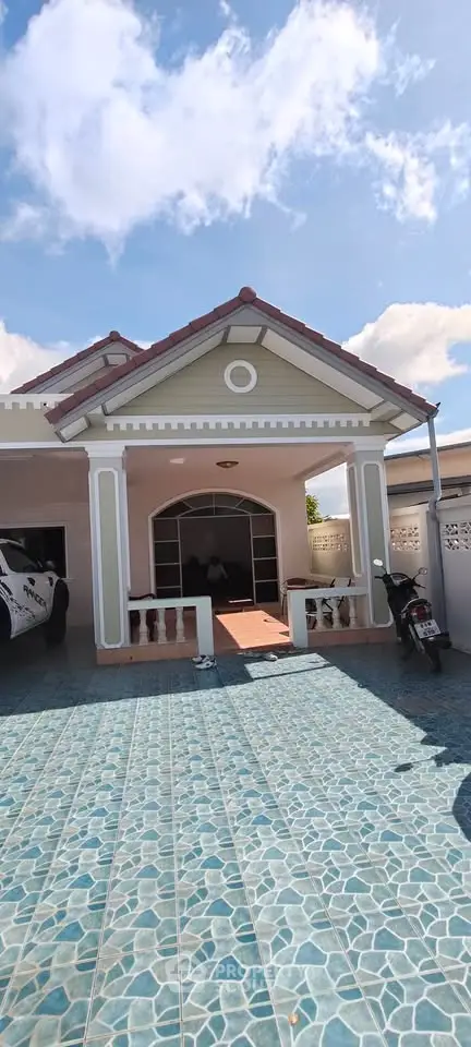 Charming single-story home with tiled driveway and covered carport, perfect for family living.