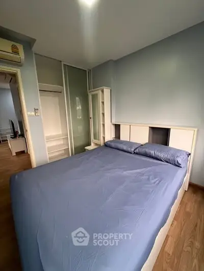 Cozy bedroom with blue bedding and modern furniture in a stylish apartment.