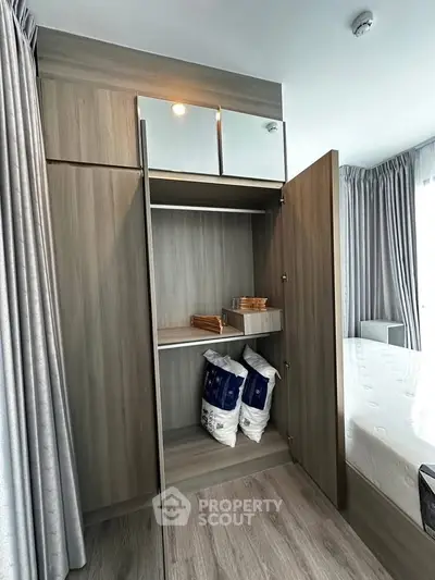 Modern bedroom with open wardrobe showcasing ample storage space and stylish design.