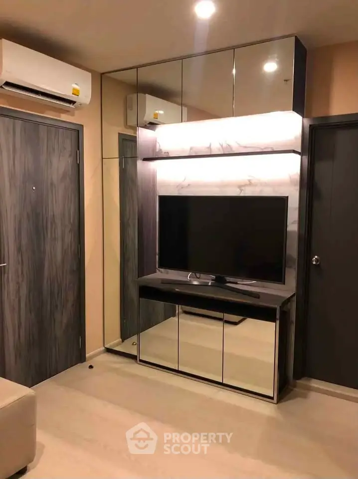 Modern living room with sleek TV unit and mirrored cabinets