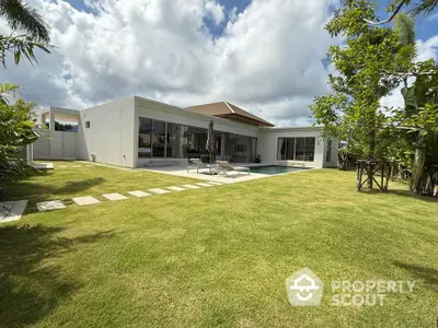 Luxurious modern villa with pool and spacious garden under a vibrant sky.