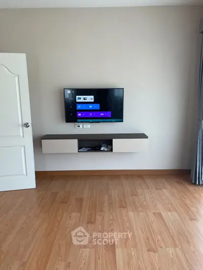 Modern living room with wall-mounted TV and wooden flooring