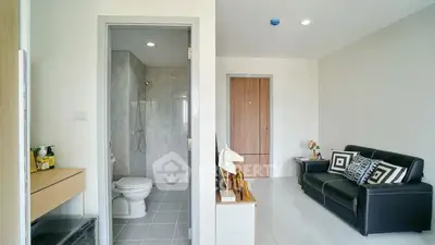 Modern apartment interior with sleek living room and adjacent bathroom, featuring stylish decor and neutral tones.