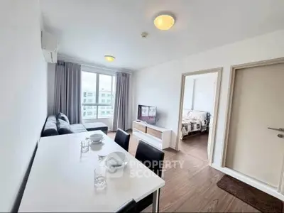 Modern living room with dining area and bedroom view in a bright apartment