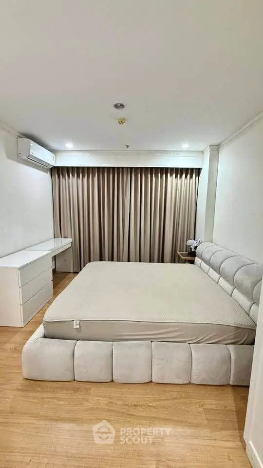 Spacious bedroom with modern design and plush bed in a serene setting.