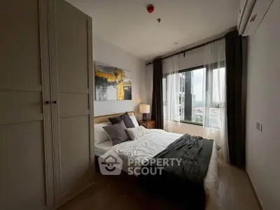 Cozy bedroom with modern decor and large window offering city view