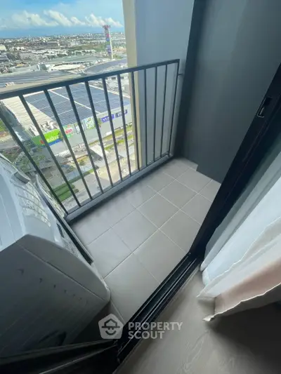 Modern apartment balcony with city view and washing machine, ideal for urban living.