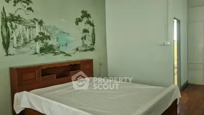 Charming bedroom with vintage mural and wooden bed frame, perfect for cozy living.