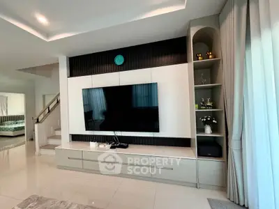Modern living room with sleek TV unit and elegant decor in a stylish home.