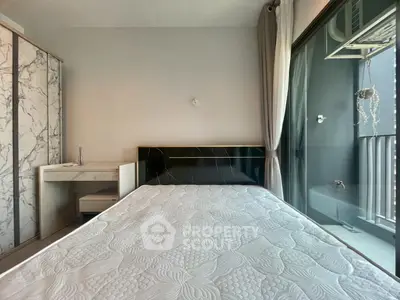 Modern bedroom with marble accents and balcony access in a stylish apartment.