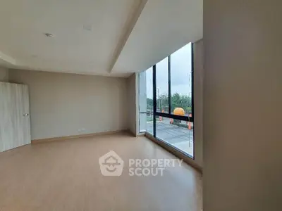 Spacious empty room with large windows offering a scenic view, perfect for customization.