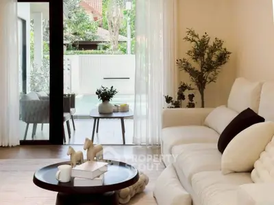 Elegant living room with plush sofa and garden view, perfect for relaxation and entertaining.