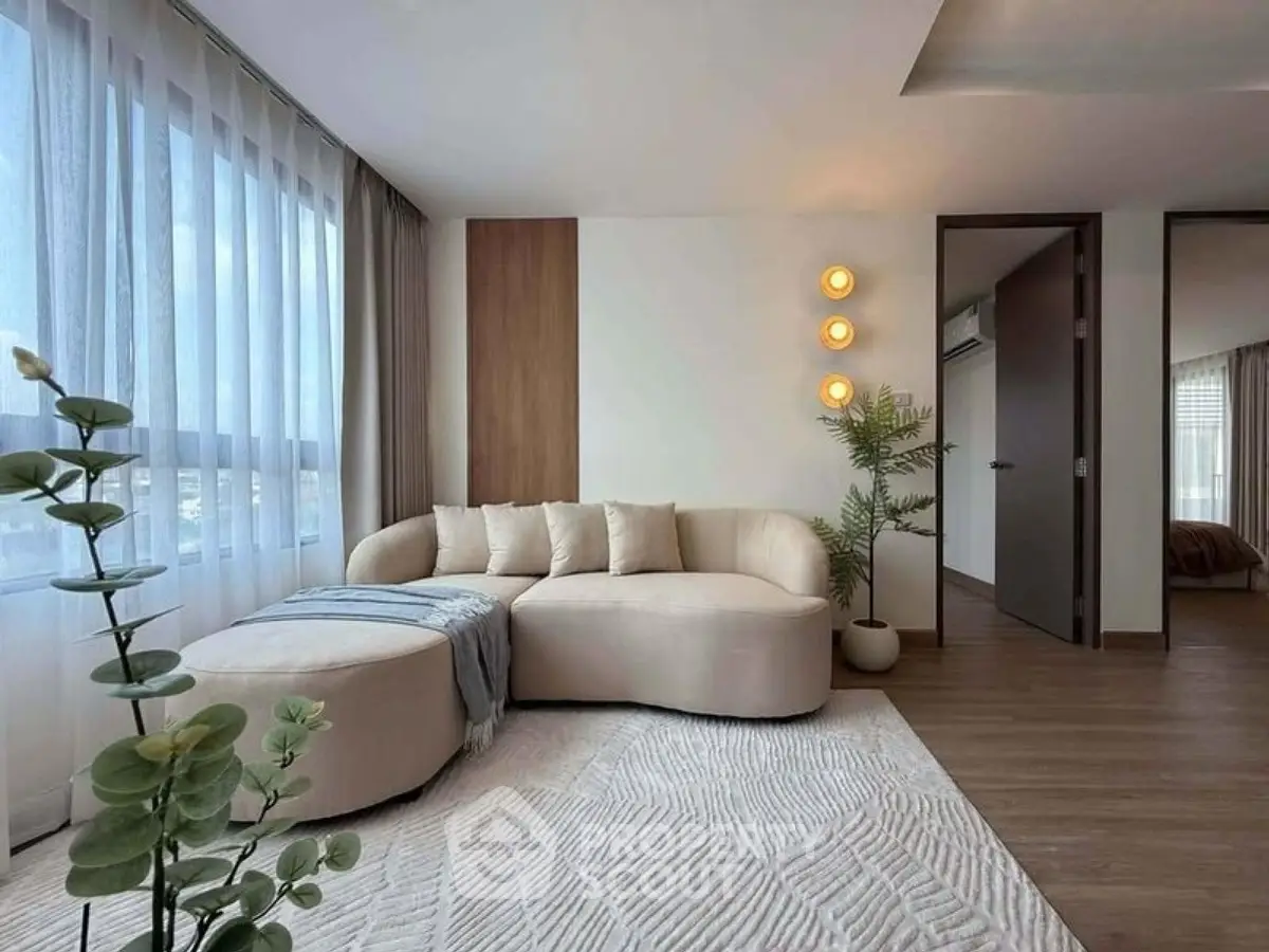 Modern living room with stylish furniture and natural light, featuring a cozy corner sofa and elegant decor.