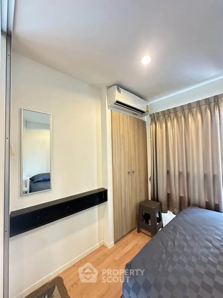 Cozy bedroom with modern decor and air conditioning, featuring a stylish wardrobe and elegant curtains.