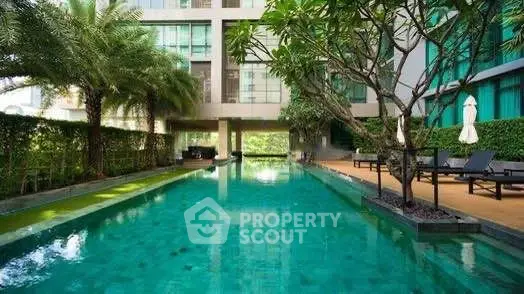 Luxurious residential pool area with lush greenery and modern design.