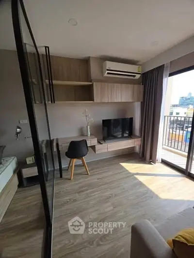 Modern living room with balcony view, featuring sleek furniture and ample natural light.