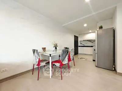 Modern dining area with stylish chairs and open kitchen layout in a contemporary apartment.