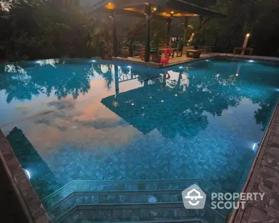 Luxurious outdoor pool with scenic view and ambient lighting