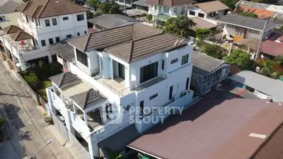Stunning aerial view of a spacious multi-story home with modern architecture in a serene neighborhood.