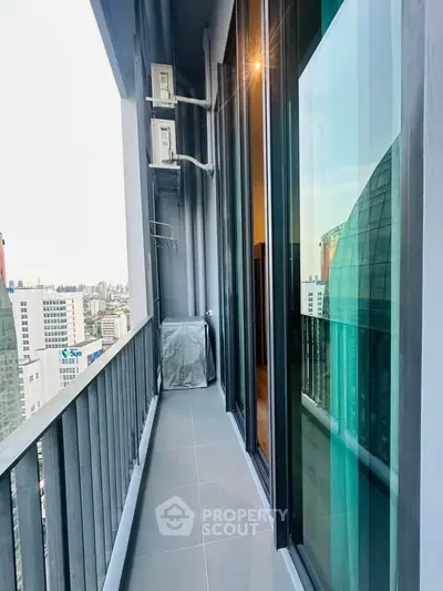 Modern high-rise balcony with city view and sleek glass doors