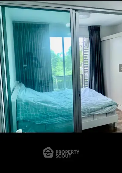 Modern bedroom with large glass windows and scenic view, featuring a cozy bed and elegant curtains.