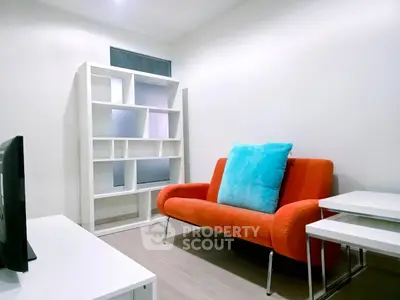 Modern living room with vibrant orange sofa and stylish shelving unit.