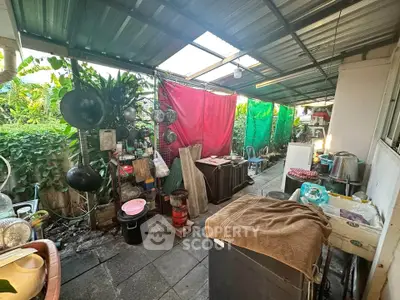 Outdoor kitchen area with metal roof and various cooking utensils, ideal for rustic culinary experiences.